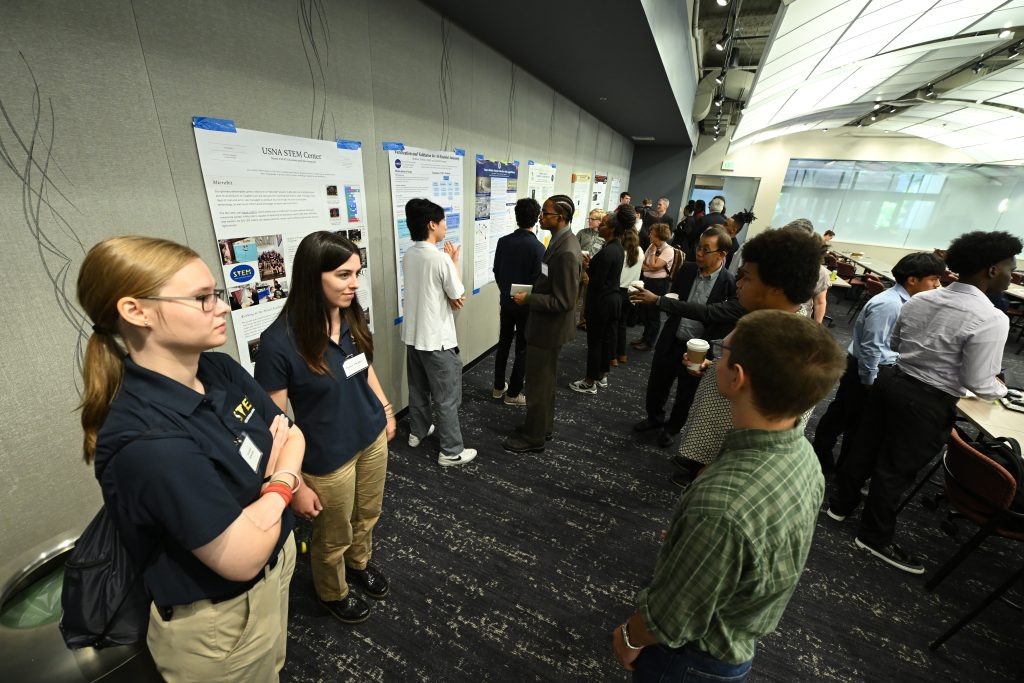 Photo of students and attendees interacting during 2026 MDSGC Symposium poster session.